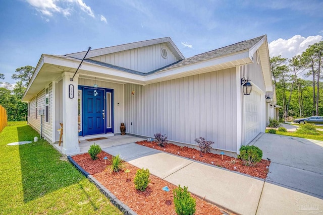 view of front of home with a front lawn, driveway, and an attached garage