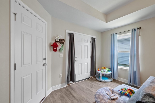 bedroom with light wood finished floors, multiple windows, and baseboards