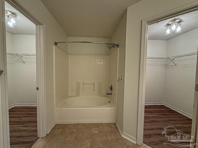 bathroom featuring a textured ceiling and shower / washtub combination