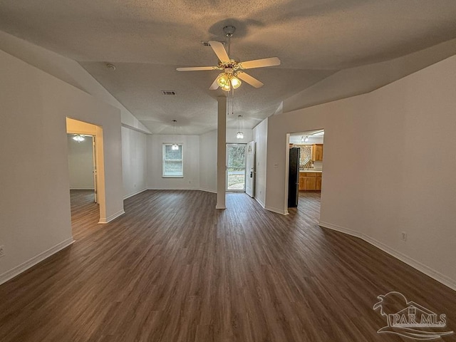 unfurnished living room with a textured ceiling, dark hardwood / wood-style floors, vaulted ceiling, and ceiling fan