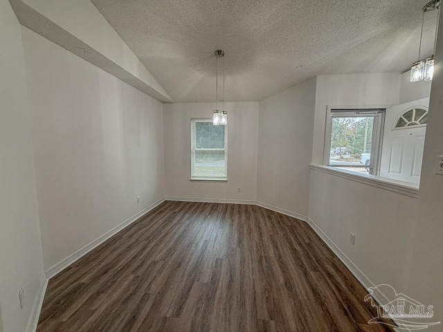 unfurnished dining area with plenty of natural light, dark wood-type flooring, and a textured ceiling