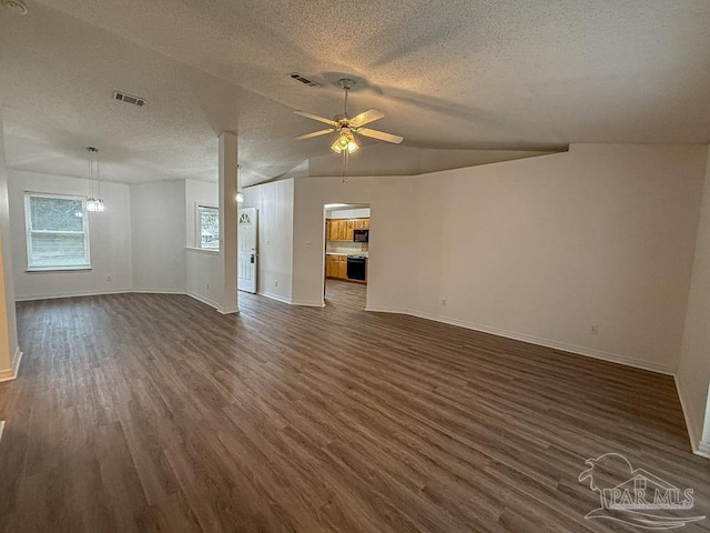 unfurnished living room with a textured ceiling, vaulted ceiling, ceiling fan, and dark wood-type flooring