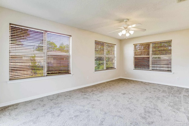 carpeted empty room featuring ceiling fan and a textured ceiling