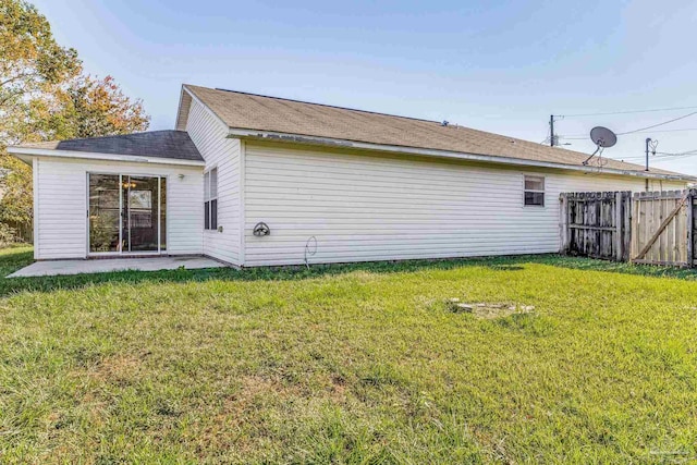 rear view of property with a yard and a patio