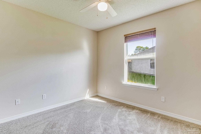 carpeted spare room with ceiling fan and a textured ceiling