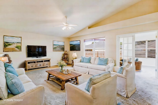 living room featuring ceiling fan, light colored carpet, and lofted ceiling