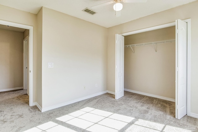 unfurnished bedroom with a closet, light colored carpet, and ceiling fan