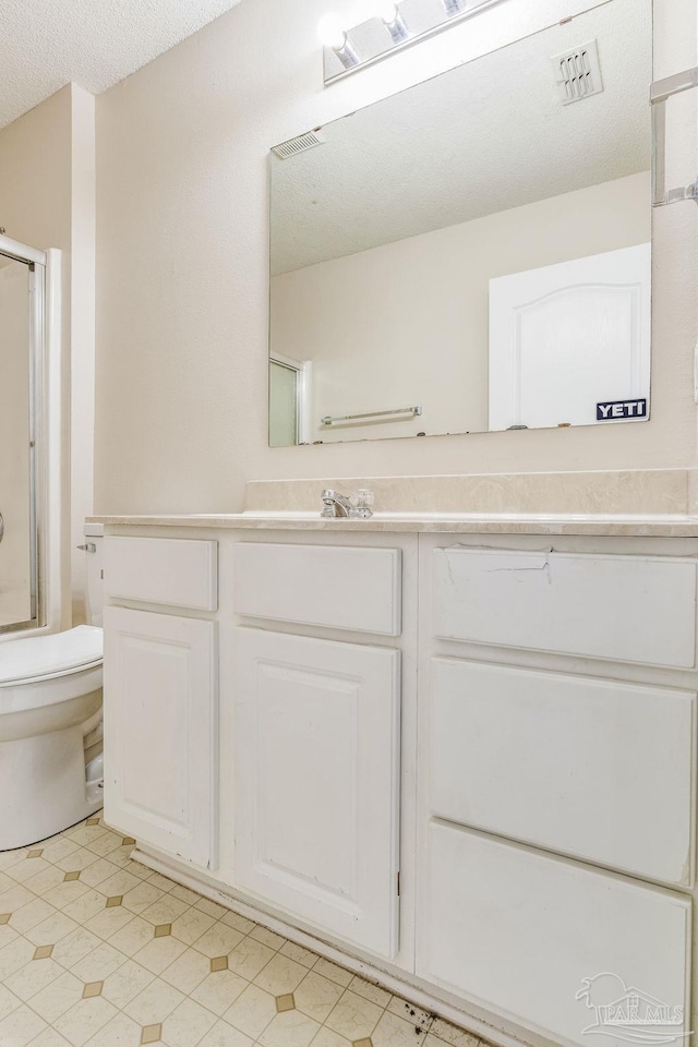 full bathroom with shower / bath combination with glass door, vanity, a textured ceiling, and toilet