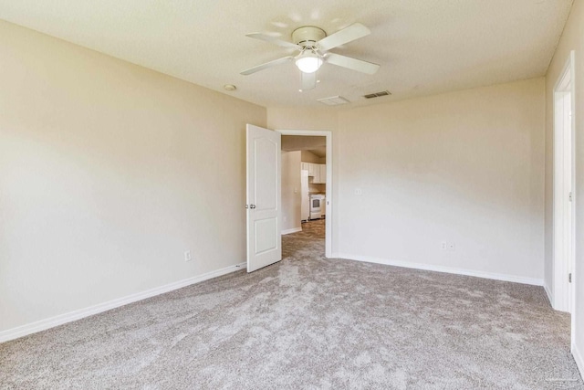 carpeted spare room with ceiling fan