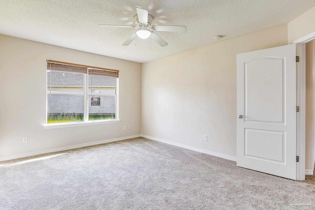 carpeted empty room featuring ceiling fan and a textured ceiling