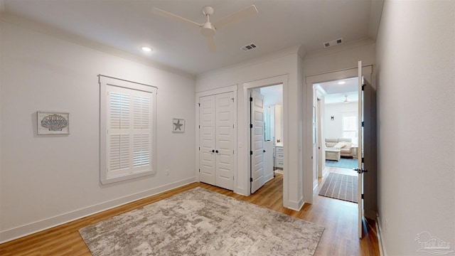 entrance foyer with ceiling fan, light hardwood / wood-style flooring, and ornamental molding