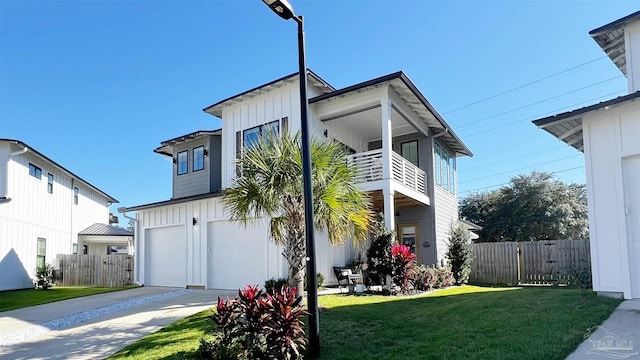 view of front facade featuring a garage, a balcony, and a front yard