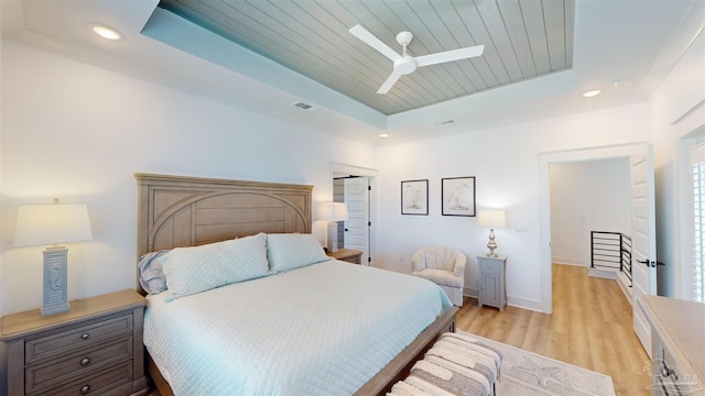 bedroom with a raised ceiling, ceiling fan, wood ceiling, and light hardwood / wood-style floors