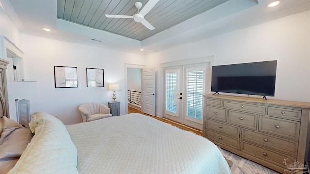 bedroom with access to exterior, ceiling fan, french doors, a raised ceiling, and light hardwood / wood-style flooring