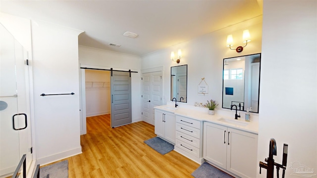 bathroom with hardwood / wood-style floors, vanity, and an enclosed shower