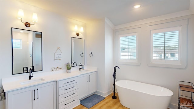 bathroom with a bath, vanity, and hardwood / wood-style flooring