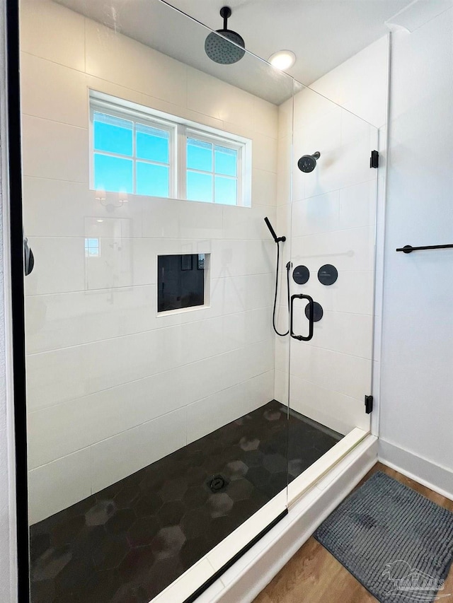 bathroom with hardwood / wood-style floors and an enclosed shower