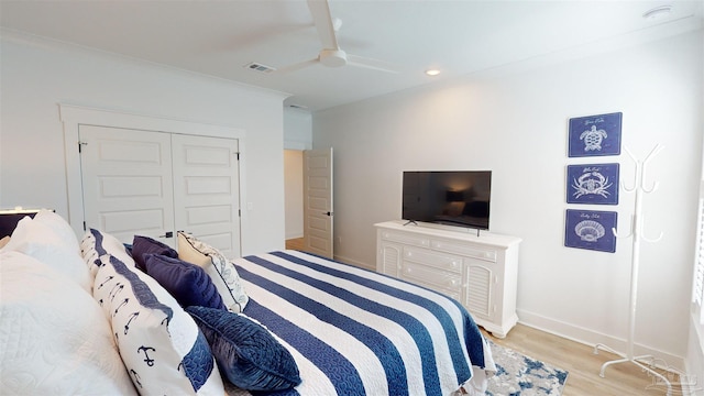 bedroom featuring crown molding, ceiling fan, a closet, and light hardwood / wood-style floors