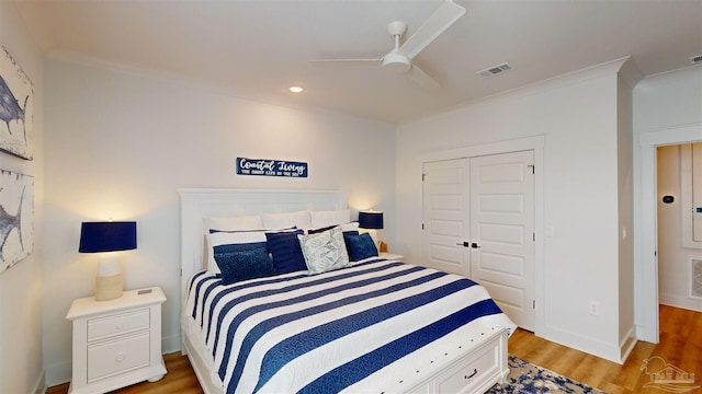 bedroom with ceiling fan, a closet, ornamental molding, and light hardwood / wood-style flooring