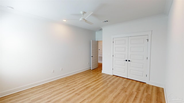 unfurnished bedroom with a closet, light hardwood / wood-style flooring, ceiling fan, and crown molding