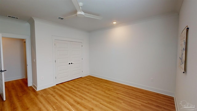 unfurnished bedroom featuring hardwood / wood-style flooring, ceiling fan, crown molding, and a closet