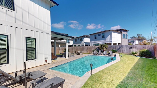 view of pool with a patio area and a yard