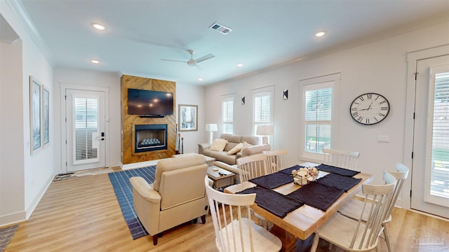 interior space featuring a fireplace, light hardwood / wood-style floors, ceiling fan, and ornamental molding