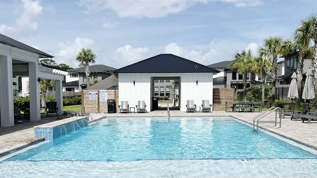 view of pool with pool water feature, an outdoor structure, and a patio