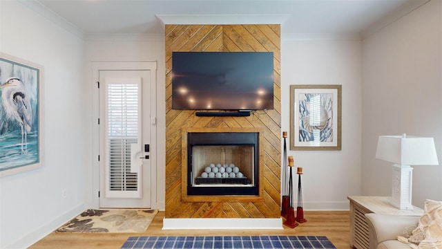 living room featuring crown molding, a fireplace, wood walls, and light wood-type flooring