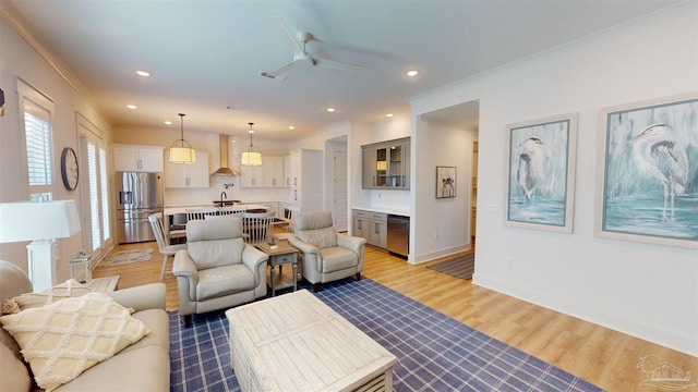 living room with ceiling fan, sink, and hardwood / wood-style flooring