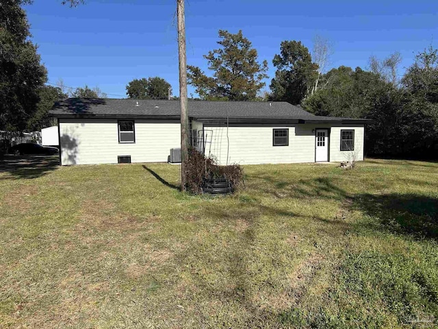 back of property featuring central AC and a lawn