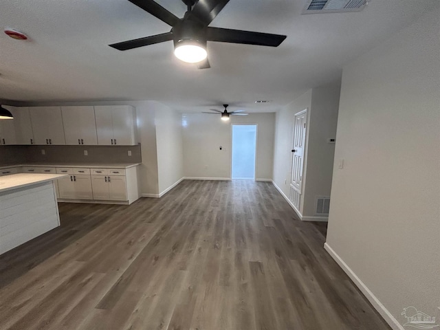 kitchen featuring visible vents, decorative backsplash, white cabinets, wood finished floors, and light countertops