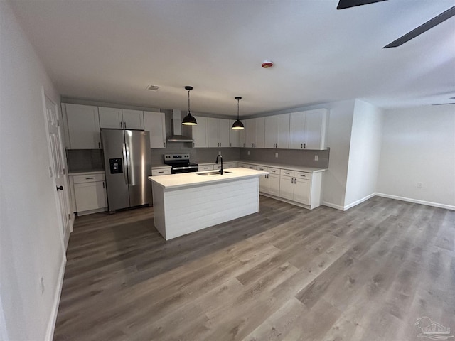 kitchen featuring wood finished floors, a kitchen island with sink, stainless steel appliances, light countertops, and a sink