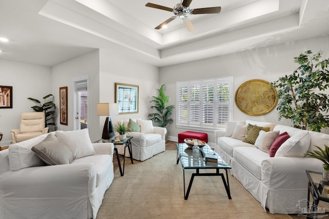 living room featuring baseboards, a raised ceiling, ceiling fan, and recessed lighting