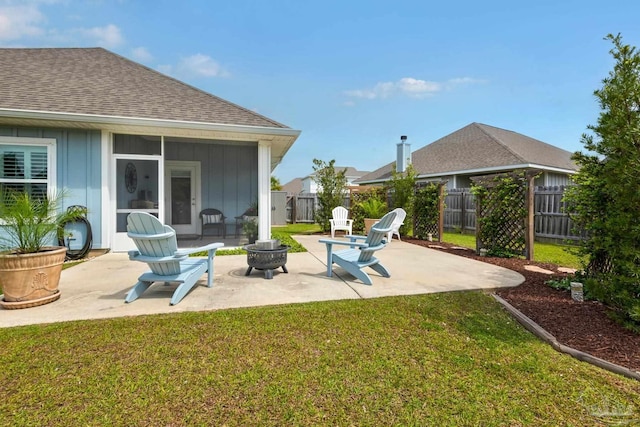 view of patio featuring a sunroom, an outdoor fire pit, and a fenced backyard