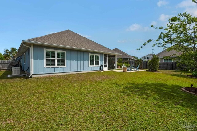 back of property featuring a fenced backyard, a patio, a yard, and board and batten siding