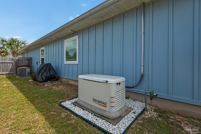 exterior space featuring board and batten siding, fence, cooling unit, and a power unit