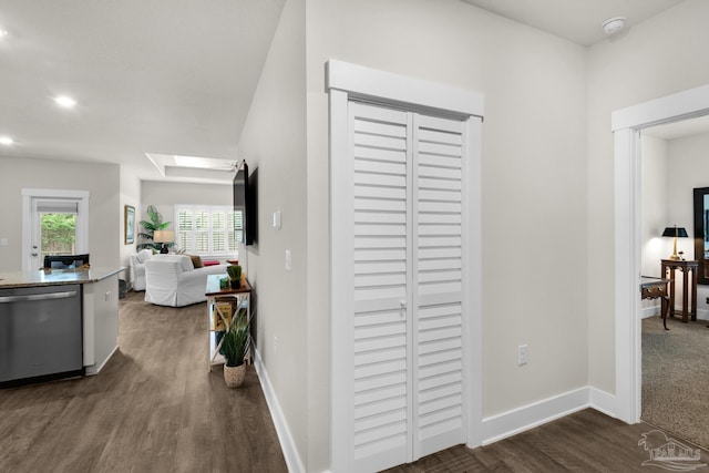 hallway with a skylight, baseboards, dark wood-type flooring, and recessed lighting