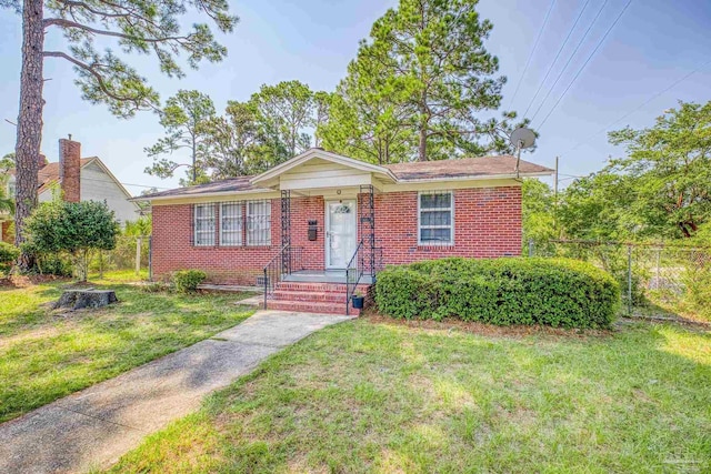 ranch-style house featuring brick siding, a front yard, and fence