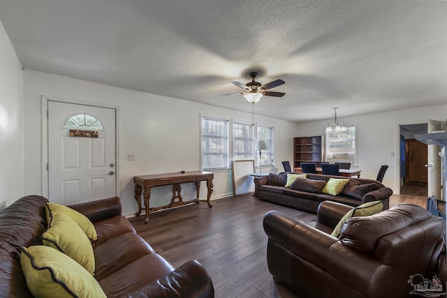 living room featuring a textured ceiling, ceiling fan with notable chandelier, and dark hardwood / wood-style flooring