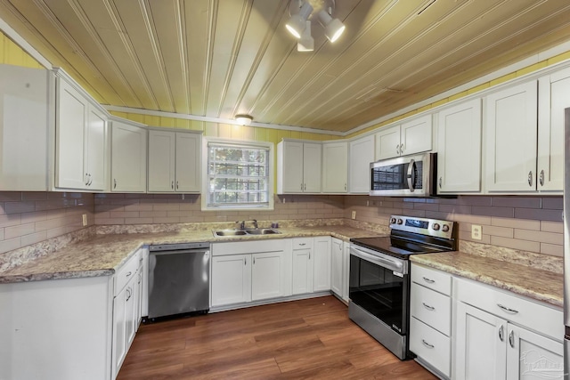 kitchen featuring dark hardwood / wood-style floors, sink, stainless steel appliances, and white cabinets