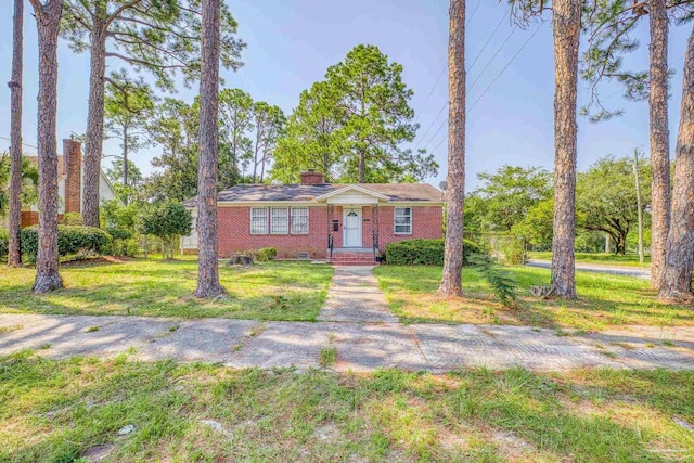 view of front of property featuring crawl space, brick siding, a chimney, and a front lawn