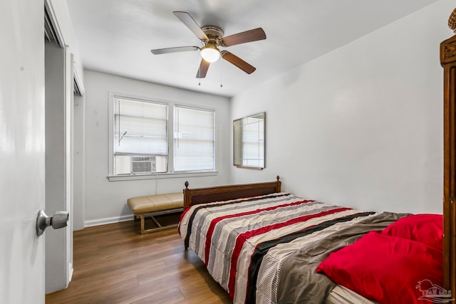 bedroom with ceiling fan, cooling unit, and hardwood / wood-style flooring