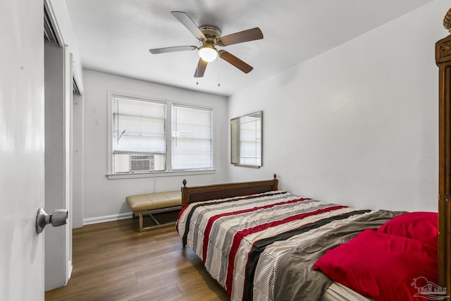 bedroom with ceiling fan, cooling unit, wood finished floors, and baseboards