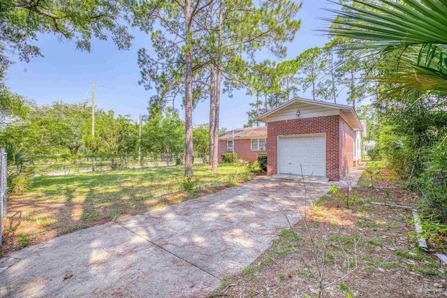 view of front of property featuring brick siding, a front yard, fence, a garage, and driveway