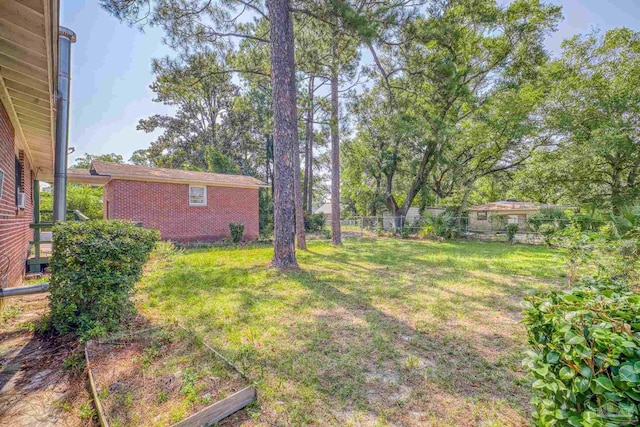 view of yard featuring fence and a vegetable garden