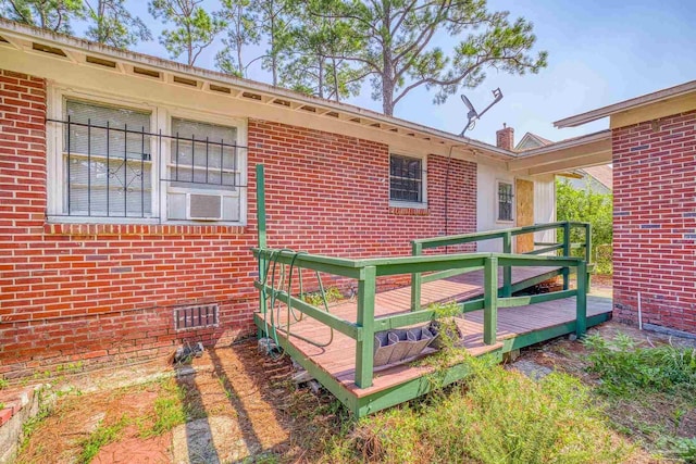 view of side of home with brick siding and a wooden deck