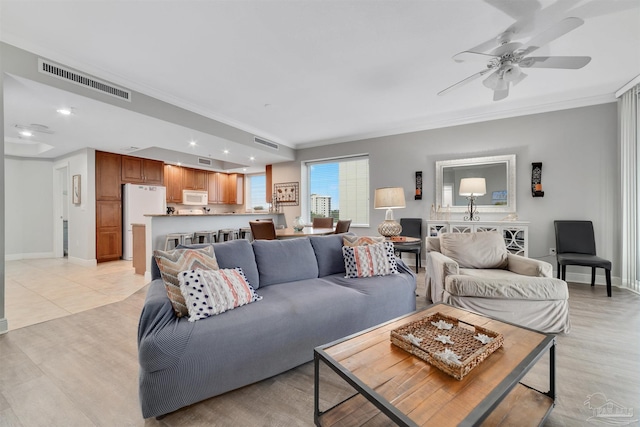 living room with crown molding, light tile patterned flooring, and ceiling fan