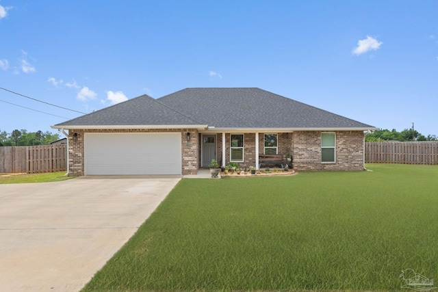 ranch-style home featuring a garage, fence, a front yard, brick siding, and driveway