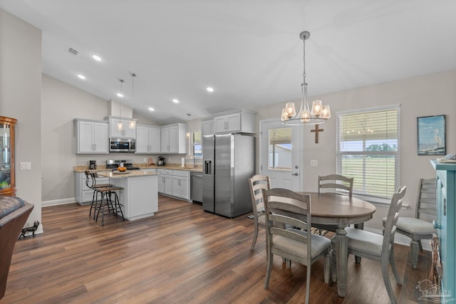 dining room with an inviting chandelier, baseboards, vaulted ceiling, and dark wood-style flooring